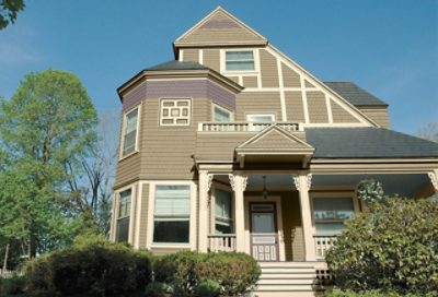 An olive coastal house with white trim and green landscaping. S-W colors featured: SW 2815, SW 2833, SW 2818.