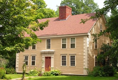 A coastal home with gold paint with red roofing and trim. S-W colors featured: SW 6129, SW 6120, SW 7598