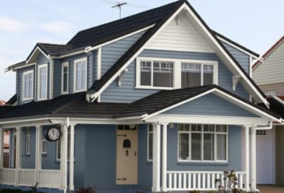 A coastal home with bluish gray paint and dark colored roofing. S-W colors featured: SW 6249, SW 7008, SW 6156