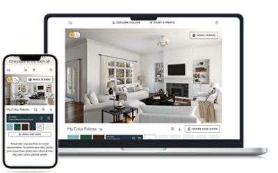A laptop and a smartphone display an interior design application. The laptop screen shows a virtual room with white walls, wooden floors, and modern furniture including sofas, a coffee table, and built-in shelves. The interface includes options like "EXPLORE COLORS," "PAINT A PHOTO," "MORE SCENES," and "ORDER FREE CHIPS." The smartphone screen shows the same app with the text "My Color Palette" and several color options below it.