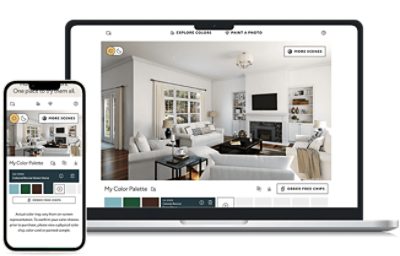 A laptop and a smartphone display an interior design application. The laptop screen shows a virtual room with white walls, wooden floors, and modern furniture including sofas, a coffee table, and built-in shelves. The interface includes options like "EXPLORE COLORS," "PAINT A PHOTO," "MORE SCENES," and "ORDER FREE CHIPS." The smartphone screen shows the same app with the text "My Color Palette" and several color options below it.