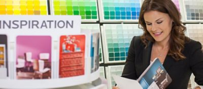 A woman looking at the Sherwin Williams Color Guide Booklet.