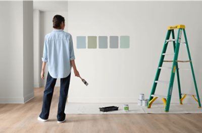 A person observing the Color to Go paint samples they just applied to the wall.