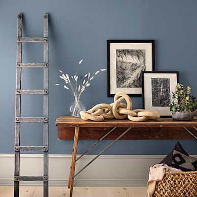A blue wall with step ladder and side table.