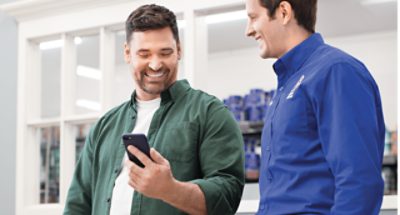 A painter and Sherwin-Williams employee looking at a phone.
