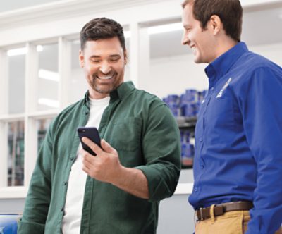 A painter and Sherwin-Williams employee looking at a phone.