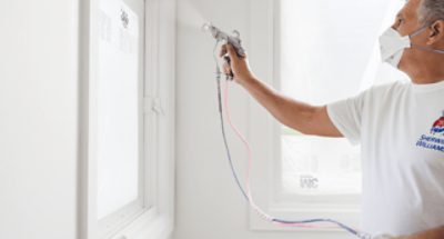 A person applying paint with a sprayer.