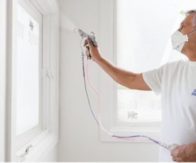 A person applying paint with a sprayer.