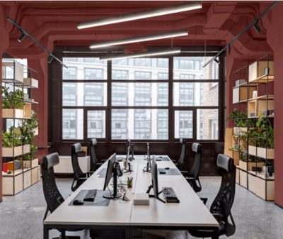 An industrial style conference room with walls and exposed ceiling painted Rookwood Red SW2802.