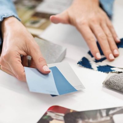 A person comparing color chips and fabric