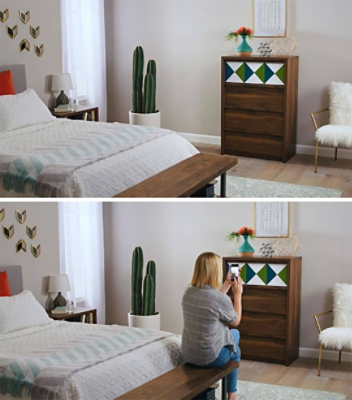 A woman is taking a picture of a two toned painted dresser