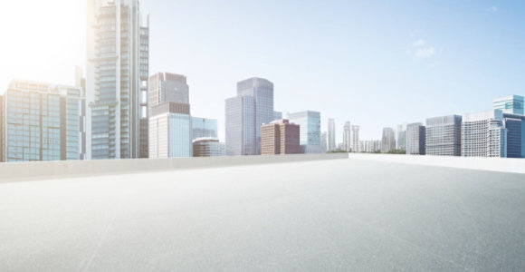 Cityscape featuring modern high-rise buildings in the background with a flat white rooftop in the foreground