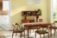 Kitchen table and chairs over an area rug, walls painted in SW 1667 Icy Lemonade, shelving full of kitchenware.