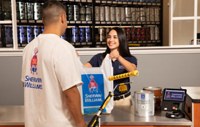 A Sherwin-Williams store associate helping a PRO customer with their purchase.