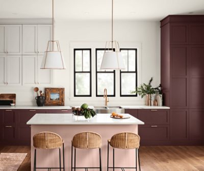 A kitchen with white marble countertops and cabinets painted Carnelian SW 7580.