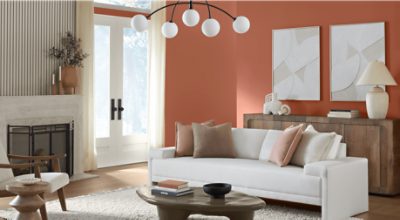 Living room painted in SW 2854 Caribbean Coral, white couch and chair, fireplace, coffee table, and other decor.