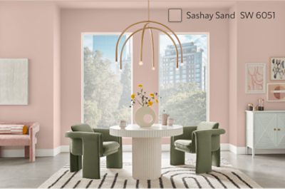 A mid-century modern inspired dining area in front of two large windows in a wall painted Sashay Sand.