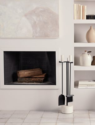 A recessed bookshelf next to a simple fireplace all painted Eider White SW 7014. 