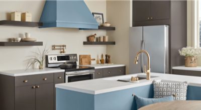 A kitchen with L -shaped island and range hood painted Smoky Azurite.