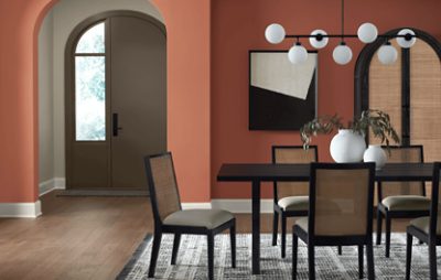 Dining room painted in SW 2854 with a table and chairs, vases, decor, and light fixture.
