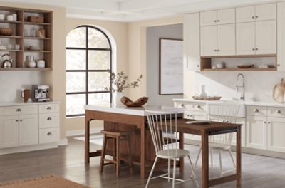 Kitchen walls painted in SW 6099 Sand Dollar with a large window and island.