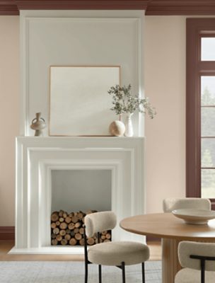 Walls painted in SW 6099 Sand Dollar, with fireplace and round table in the room.