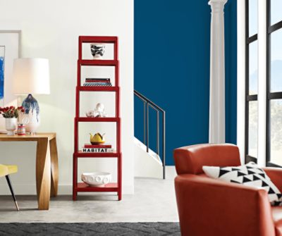A living room with a ladder shelf painted Peppery SW 6615 against a bright white wall.