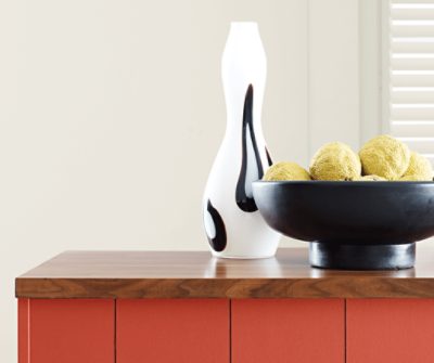 A medium-dark stained butcher block countertop with cabinets painted Peppery SW 6615.