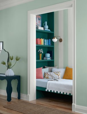 Wall painted in SW 6456 Slow Green, shelving in a room with decor and day bed.