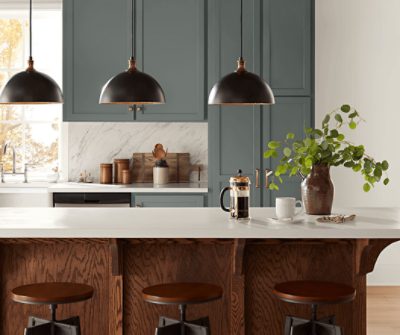 Kitchen cabinets painted in SW 7622 Homburg Gray with white countertops and wood accents.