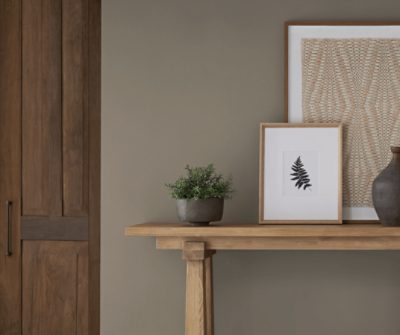Entryway painted in SW 9172 Studio Clay with wooden table and decor on top.