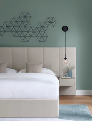 Bedroom walls painted in Halcyon Green SW 6213 with a neutral bed and bedframe.