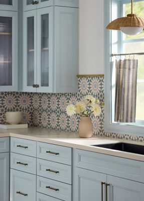 Kitchen cabinets painted in SW 6218 Tradewind, printed backsplash.