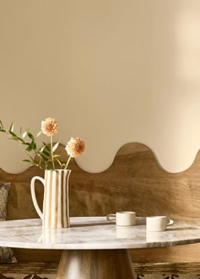 Decorative vase with flowers on a countertop, wall behind it painted in SW 7688 Sundew.