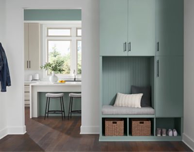 Entryway with cabinets painted in Halcyon Green SW 6213, peek of a kitchen.