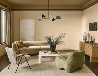 Living room with window, couch, and two chairs, walls painted in SW 7688 Sundew.