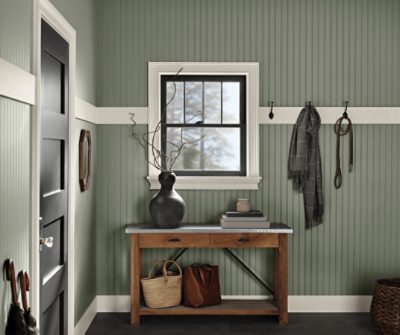 A paneled entryway painted Evergreen Fog SW 9130 with creamy white accents.