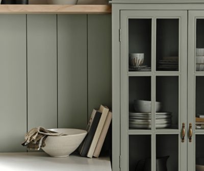 A paneled backsplash and glass front cabinet all painted Evergreen Fog SW 9130.