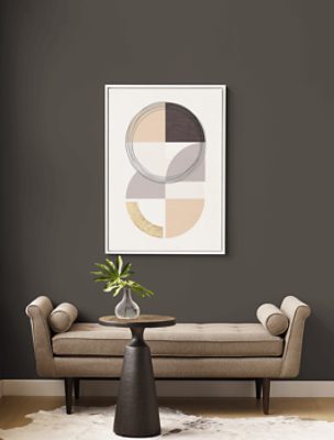 A divan with modern art hanging on a wall painted in SW 7048 Urbane Bronze.