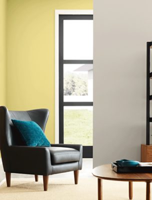 A room painted in SW 0073 Chartreuse with a leather accent chair and round coffee table.
