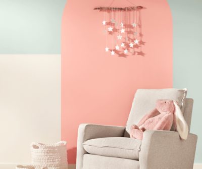 Nursery with a SW 6611 Jovial color blocked wall and a star mobile. 