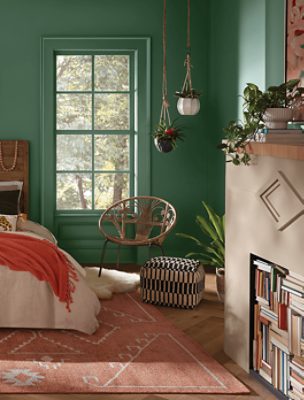 A boho-inspired bedroom painted Kale Green SW 6460.