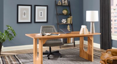 Office painted in SW 6249 Storm Cloud with light decor, a bookshelf, wooden desk over a large rug.