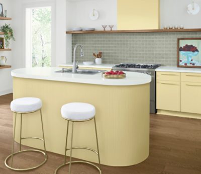 Kitchen bar and cabinets painted in SW 1667 Icy Lemonade, white and gold bar stools, some shelving with kithcenware.