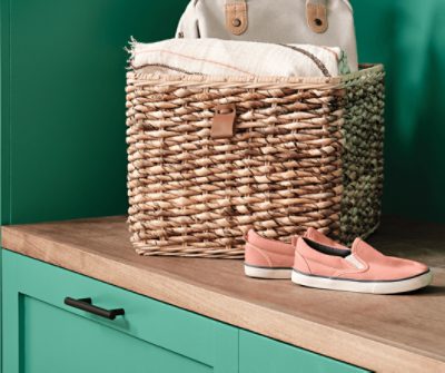 A pair of shoes and a wicker basket sitting on top of the wood bench of the entryway built-in painted Alexandrite SW 0060.