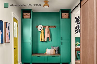 An entryway with built-in shelving, bench and coat hooks painted Alexandrite SW 0060.