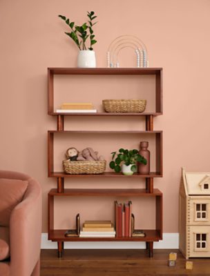 A Mid-Century Modern bookshelf against a wall painted in SW 0069 Rose Tan.