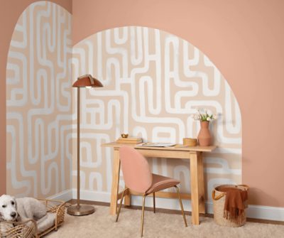 An office painted in SW 0069 Rose Tan with an accent geometric wall mural. 