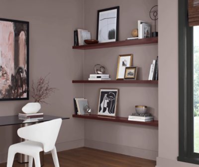 Office area painted in Chinchilla SW 6011, modern furniture with shelving that has decor.