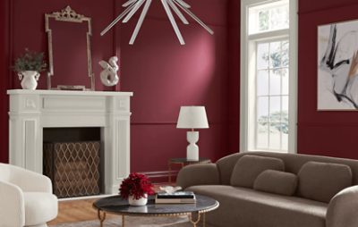 Living room painted in SW 7578 Borscht, brown couch, white fireplace, window, minimal decor.